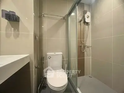 Modern bathroom with sleek shower and toilet in neutral tones.