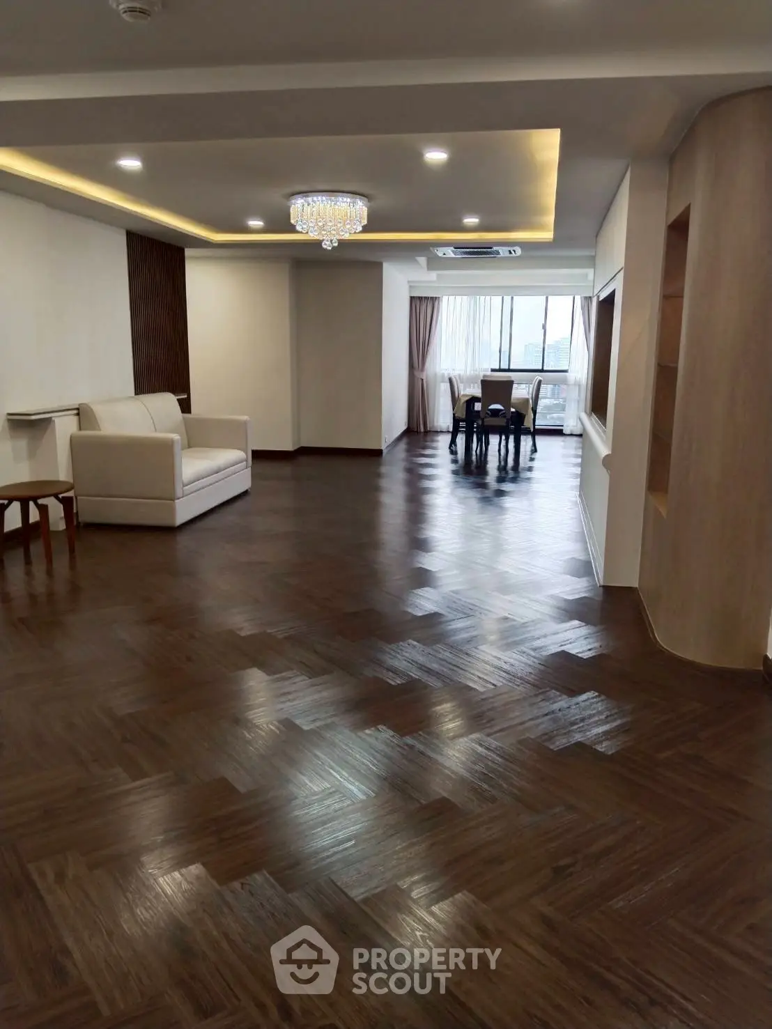 Spacious living room with elegant wooden flooring and modern lighting