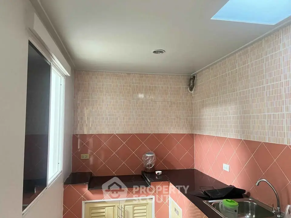 Charming kitchen with modern tiles and sleek countertops, perfect for culinary enthusiasts.