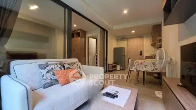 Modern living room with cozy sofa and open kitchen layout in stylish apartment.