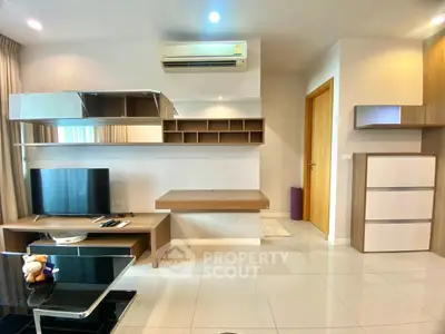 Modern living room with sleek furniture and wall-mounted storage in a stylish apartment.