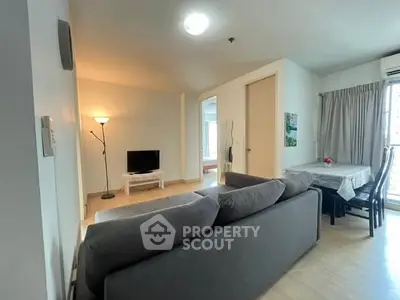 Spacious living room with modern decor and natural light in a cozy apartment.