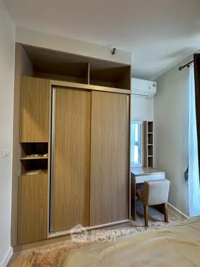 Modern bedroom with built-in wardrobe and cozy study nook, perfect for urban living.