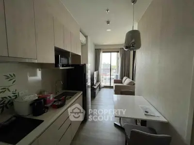 Modern compact kitchen and living area with city view in a stylish apartment