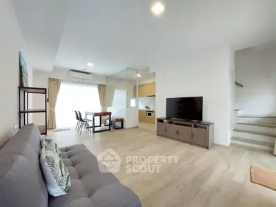 Spacious modern living room with open kitchen and natural light
