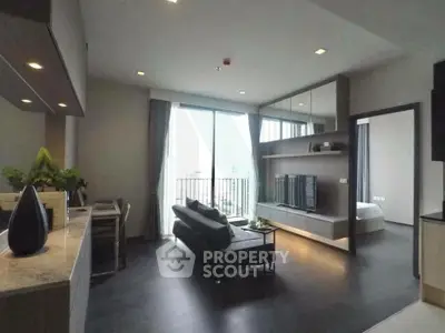 Modern living room with sleek design and large windows offering city views, adjacent to a cozy bedroom.