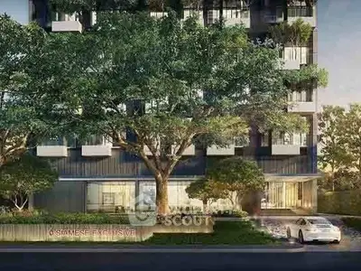 Modern building exterior with lush greenery and luxury car at entrance