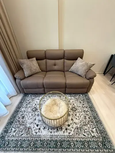 Stylish living room with cozy brown sofa and elegant rug, perfect for relaxation.