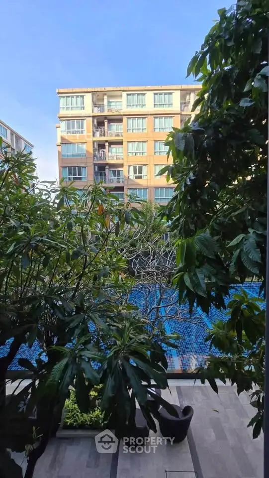 Stunning apartment view with lush greenery and poolside tranquility