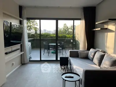 Modern living room with large sliding doors to a spacious balcony, perfect for relaxation.