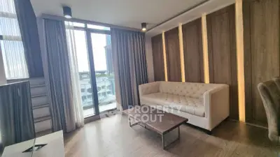 Modern living room with large windows and stylish decor in a high-rise apartment.