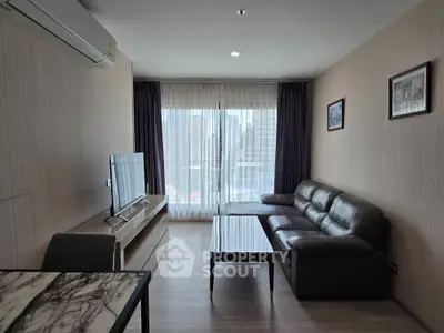 Modern living room with city view, featuring sleek furniture and natural light.