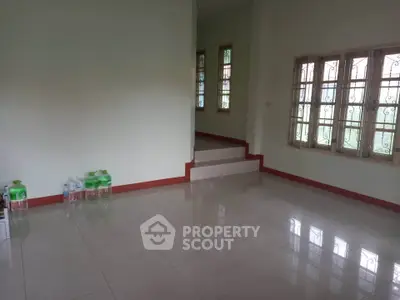 Spacious empty room with tiled flooring and large windows, perfect for customization.