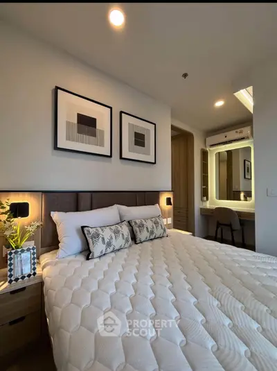 Modern bedroom with cozy decor and stylish artwork, featuring a comfortable bed and elegant lighting.