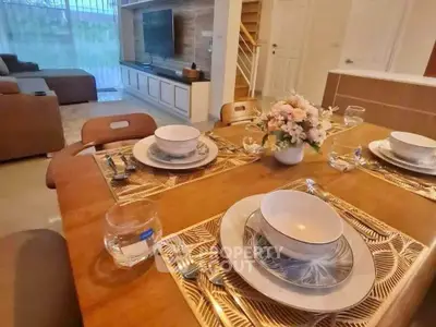 Elegant dining area with stylish table setting and cozy living room view.