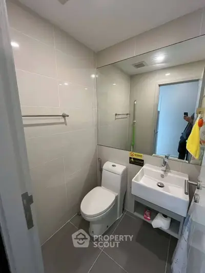 Modern bathroom with sleek fixtures and large mirror in a contemporary apartment.