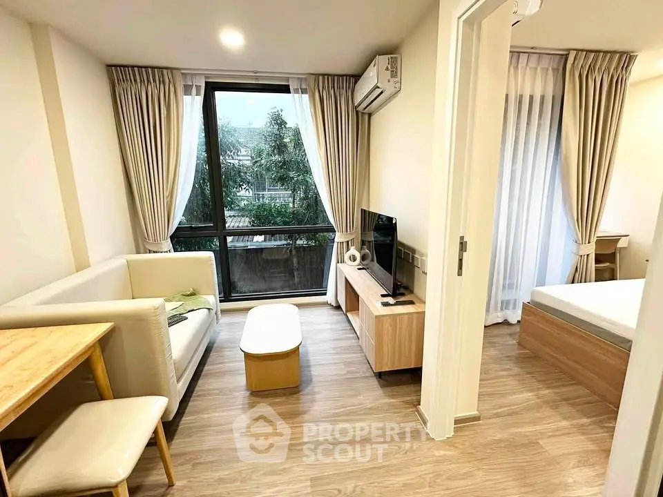 Modern living room with cozy seating and natural light in a stylish apartment.