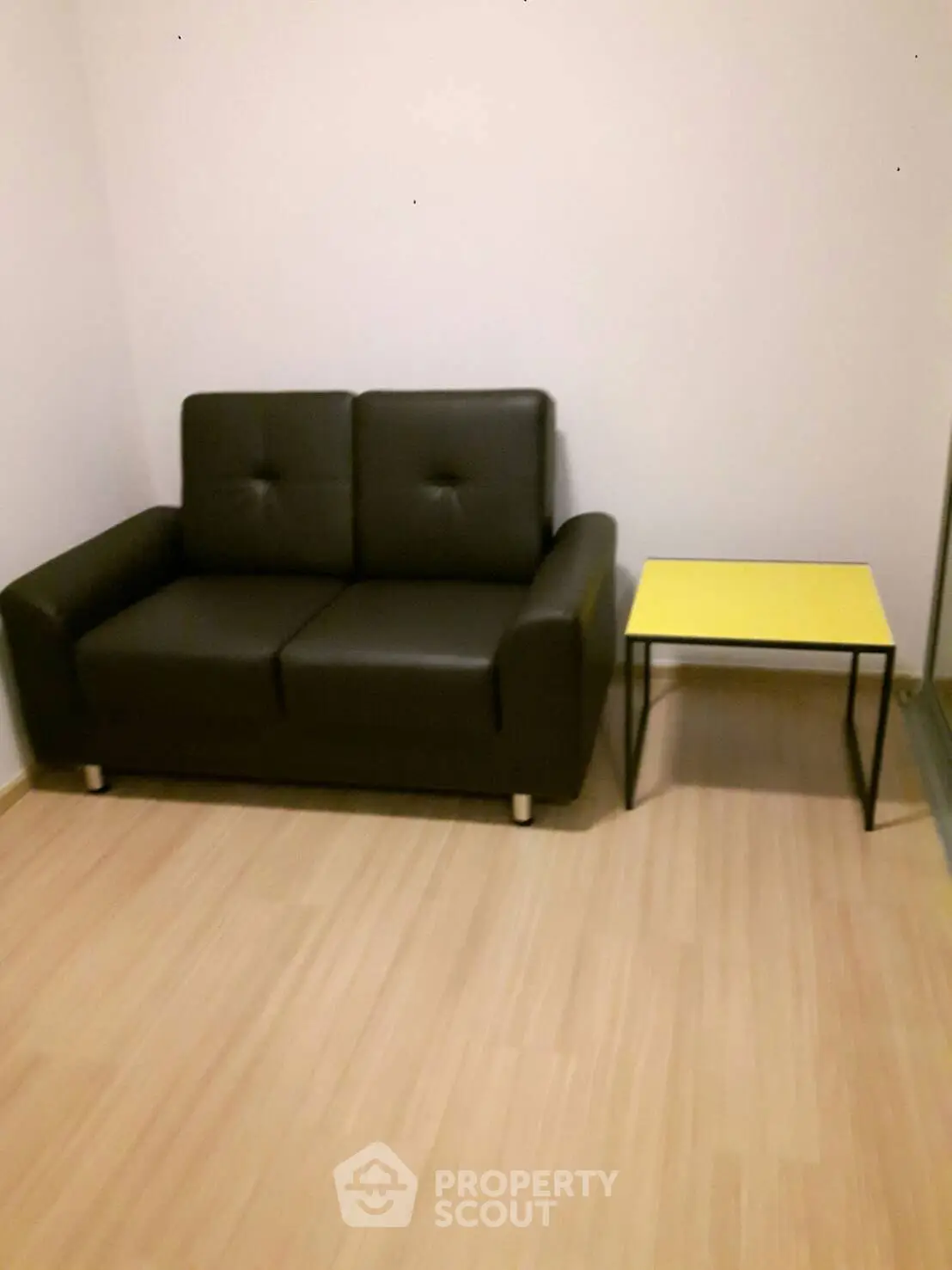 Cozy living room with modern black sofa and stylish yellow side table