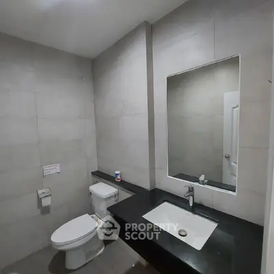 Modern bathroom with sleek black countertop and large mirror