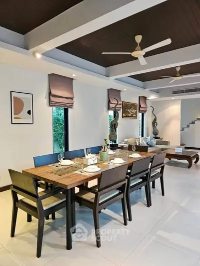 Elegant dining area with modern decor and ceiling fans, perfect for entertaining guests.