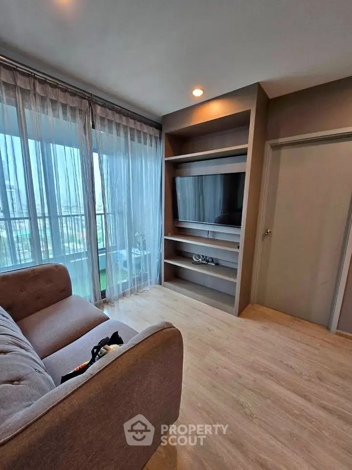Modern living room with large windows and stylish furniture in a cozy apartment.