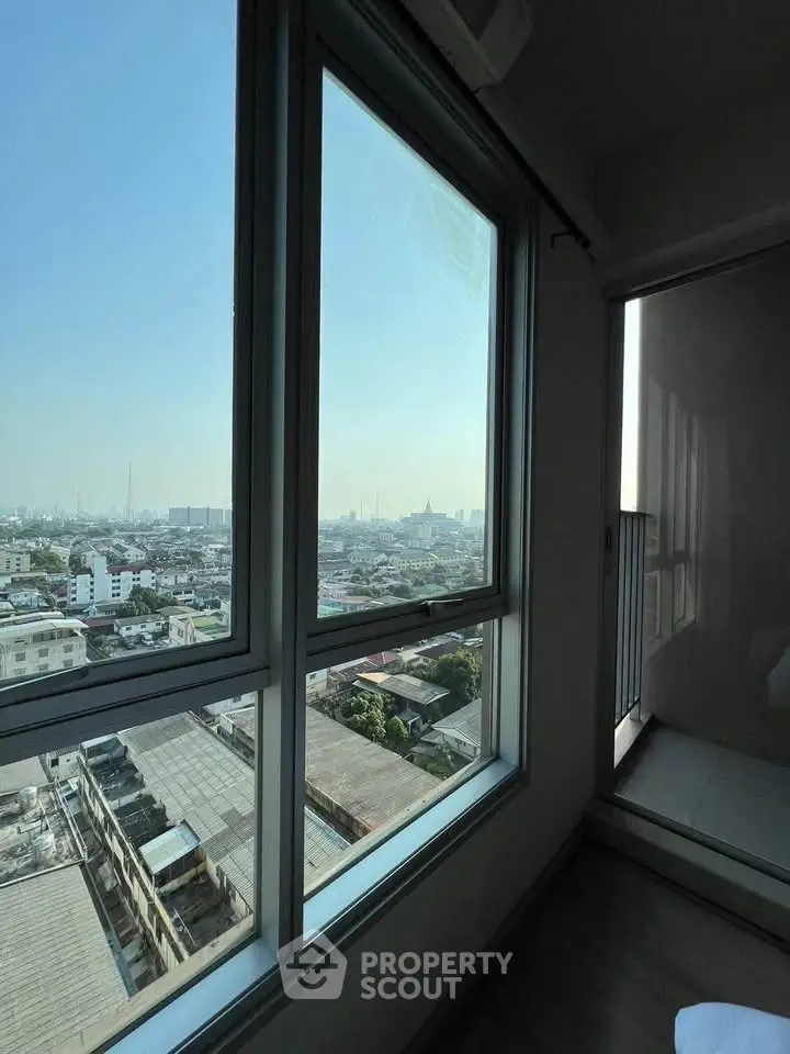 Stunning cityscape view from high-rise apartment window, offering panoramic urban vistas.