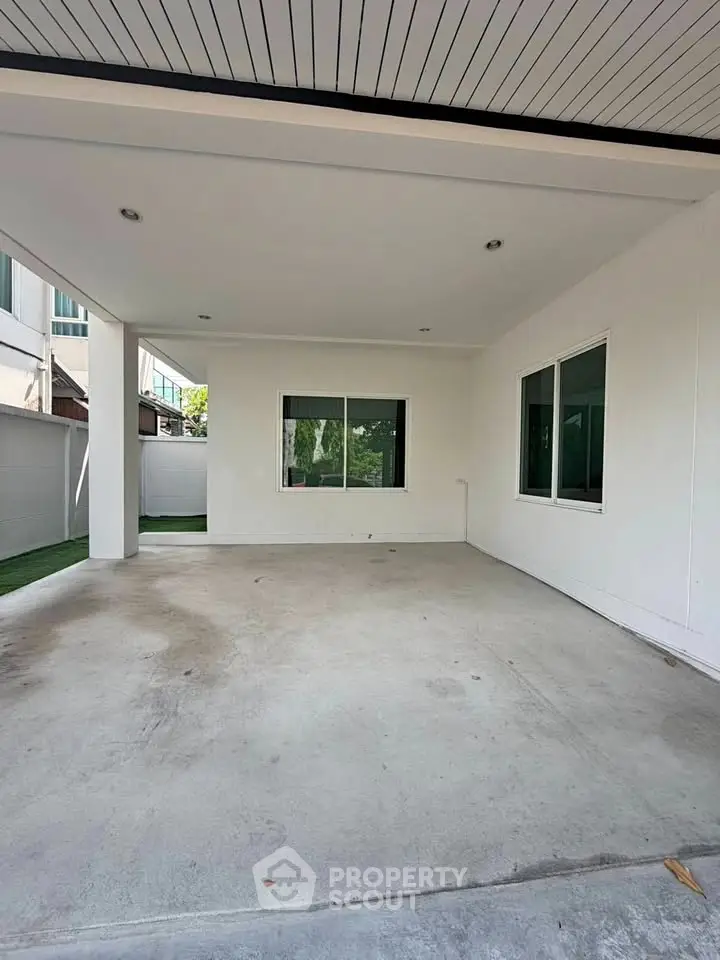 Spacious covered parking area in modern residential property with sleek design and ample natural light.