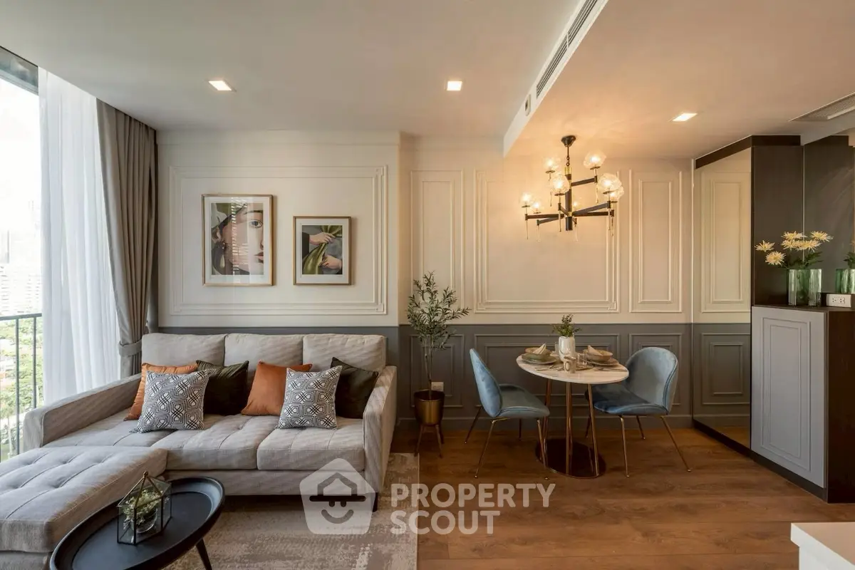 Elegant living room with stylish decor and dining area, featuring modern chandelier and cozy seating.
