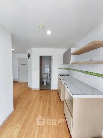 Modern kitchen with open layout and wooden flooring in a bright apartment