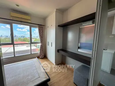 Bright bedroom with city view, built-in wardrobe, and modern furnishings in a stylish apartment.