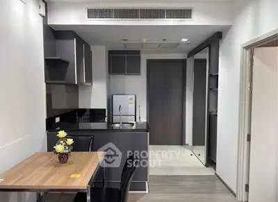 Modern kitchen with sleek cabinetry and dining area in a stylish apartment.