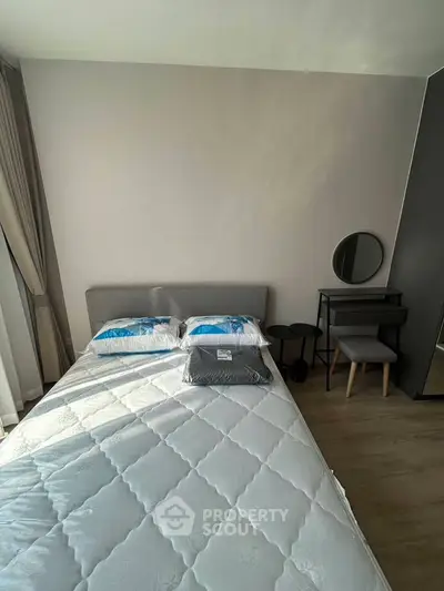 Modern bedroom with stylish decor and natural light, featuring a cozy bed and elegant vanity set.