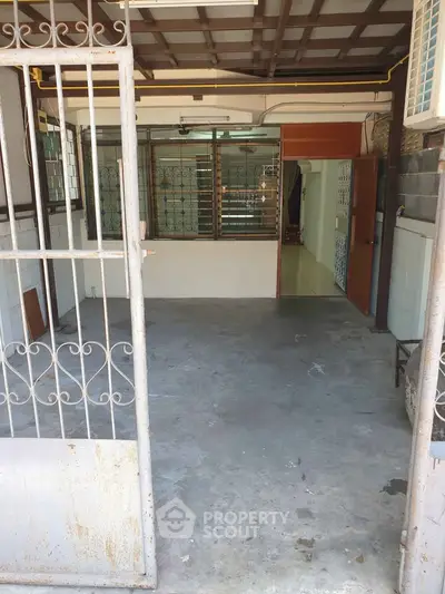 Spacious entryway with metal gate and tiled flooring, ideal for customization.