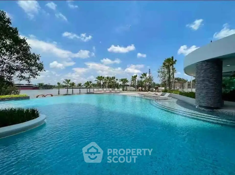 Luxurious resort-style pool with palm trees and modern architecture under a clear blue sky.