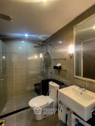 Modern bathroom with sleek design, glass shower, and elegant fixtures in a contemporary apartment.