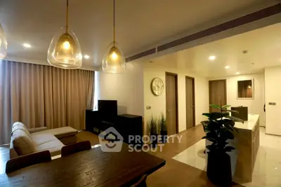 Modern open-plan living room with stylish lighting and cozy seating area.