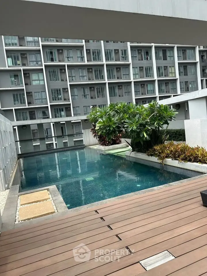 Modern apartment complex with stylish pool and lush greenery, offering a serene urban oasis.