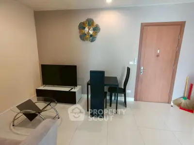 Modern living room with sleek furniture and wall art, featuring a TV and dining area.
