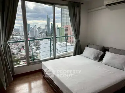 Modern bedroom with city view from large windows in high-rise apartment.