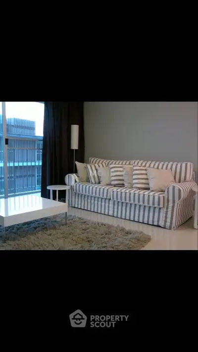 Modern living room with striped sofa and city view, perfect for urban living.