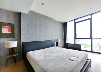 Luxurious bedroom with modern decor and large windows offering stunning city views.