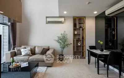 Modern living room with elegant decor and dining area, featuring a cozy sofa and stylish shelving.