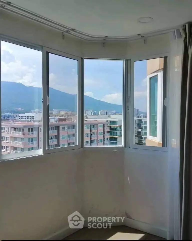 Bright corner unit with panoramic city and mountain views through large windows.