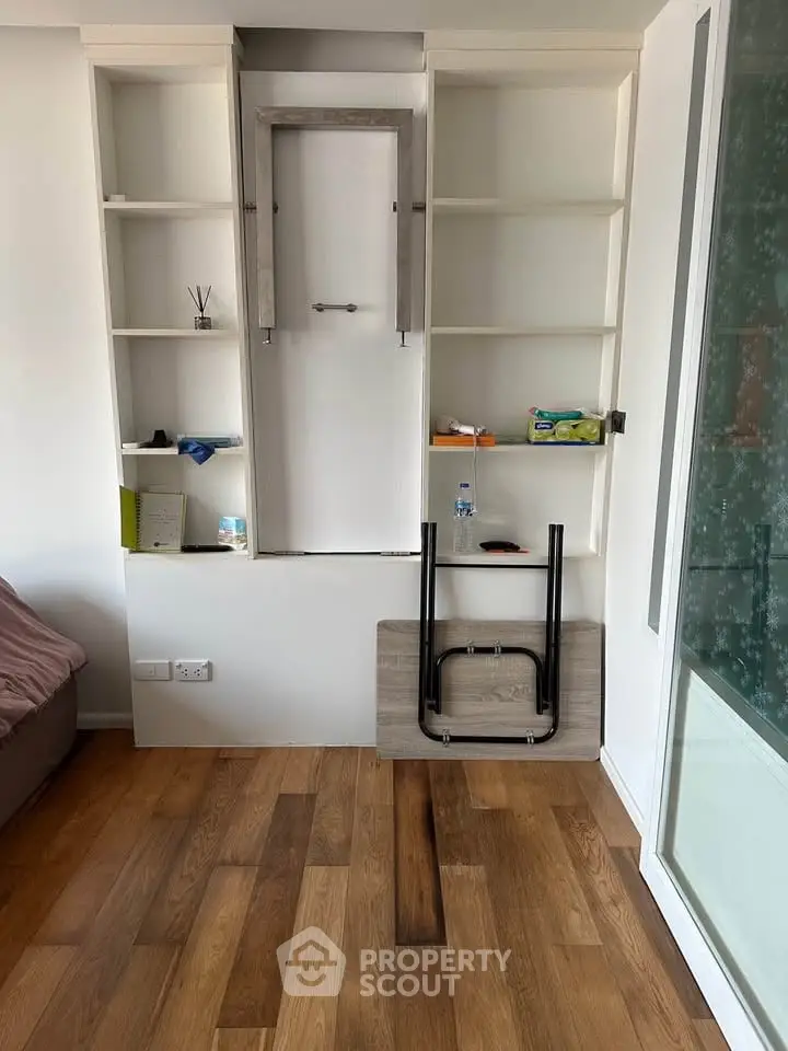 Modern living room with built-in shelves and wooden flooring, showcasing minimalist design.