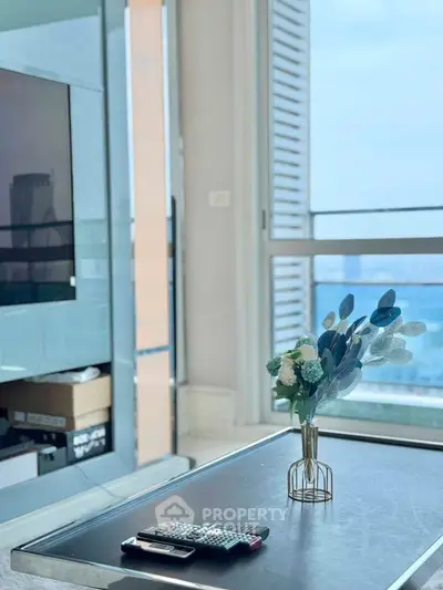 Modern living room with sleek TV setup and stunning city view from large windows.