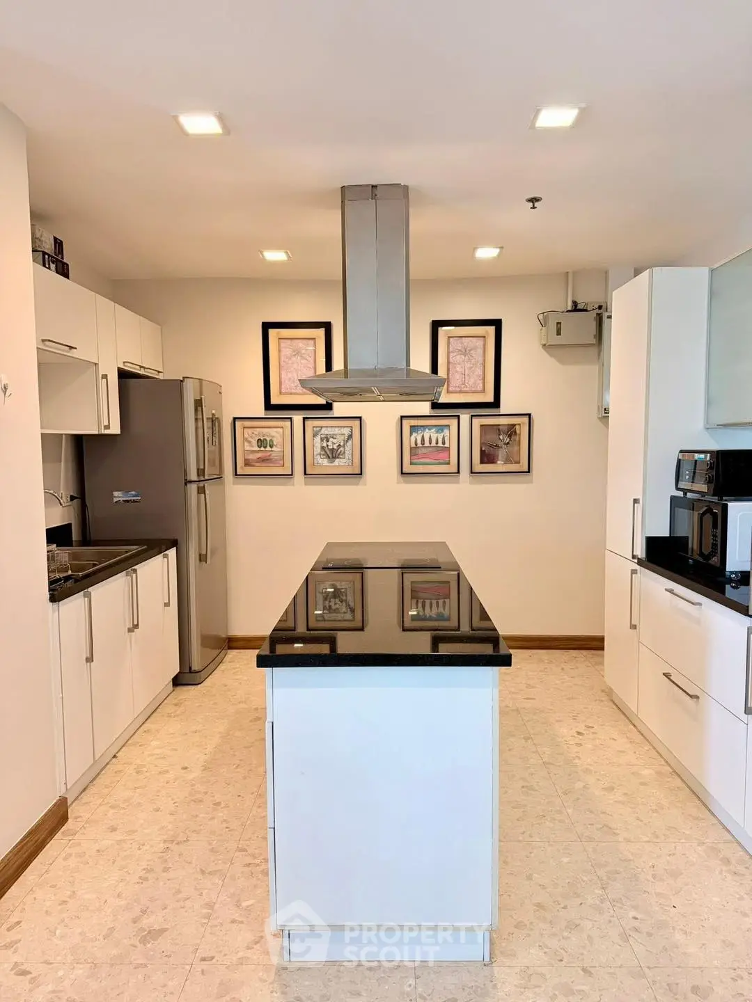 Modern kitchen with sleek white cabinets and central island, featuring stainless steel appliances and elegant decor.
