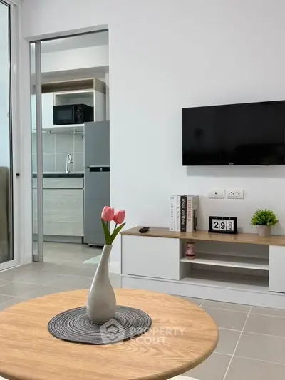 Modern living room with sleek TV setup and stylish kitchen view