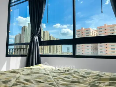 Spacious bedroom with large window offering stunning city views in modern apartment.