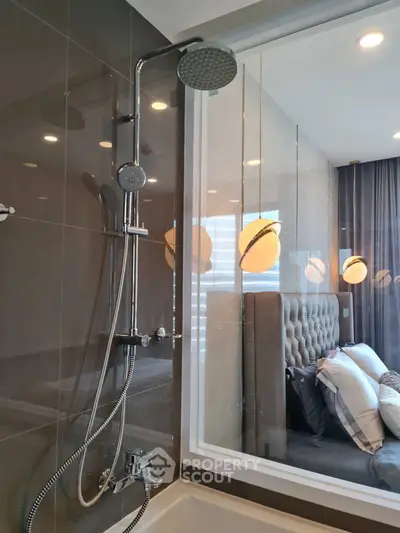 Modern bathroom with sleek shower and view into stylish bedroom