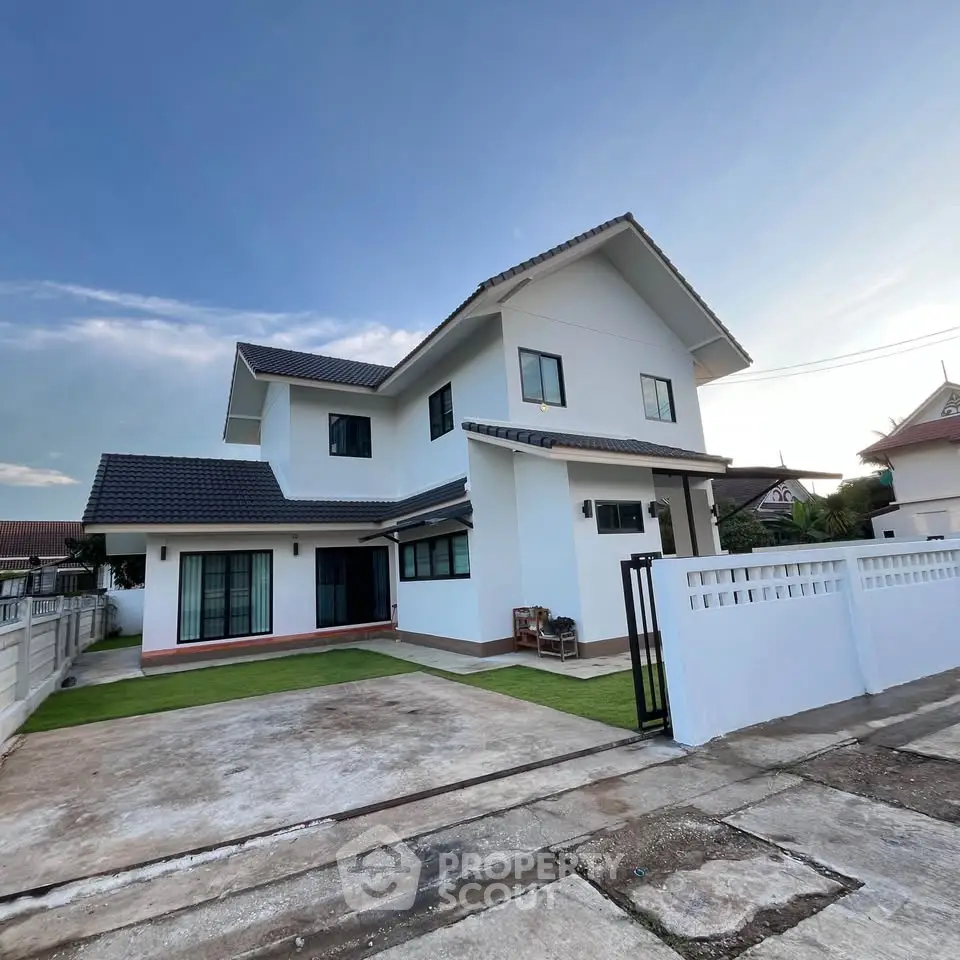 Modern two-story house with spacious driveway and manicured lawn in a serene neighborhood.